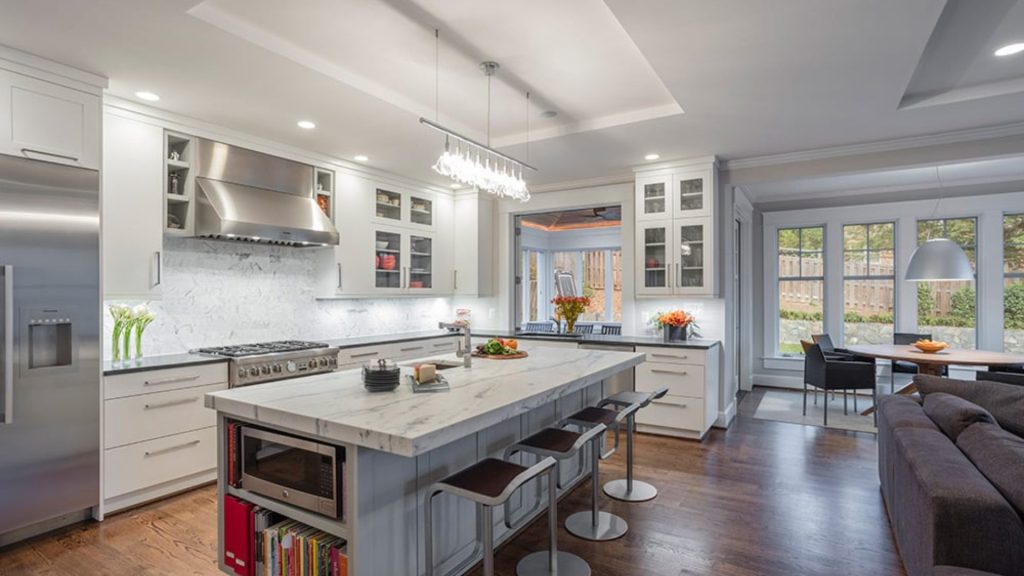 Open-concept kitchen with no walls, large island, and natural light flowing into connected living and dining areas