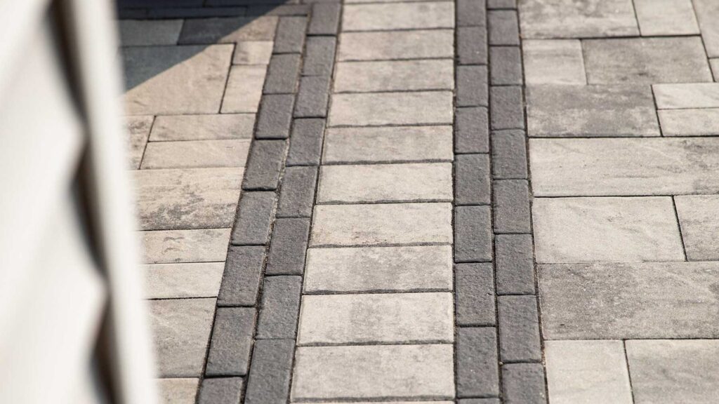 Patio paver design with contrasting inlays Paver layout with decorative borders and inlays for patios and walkways