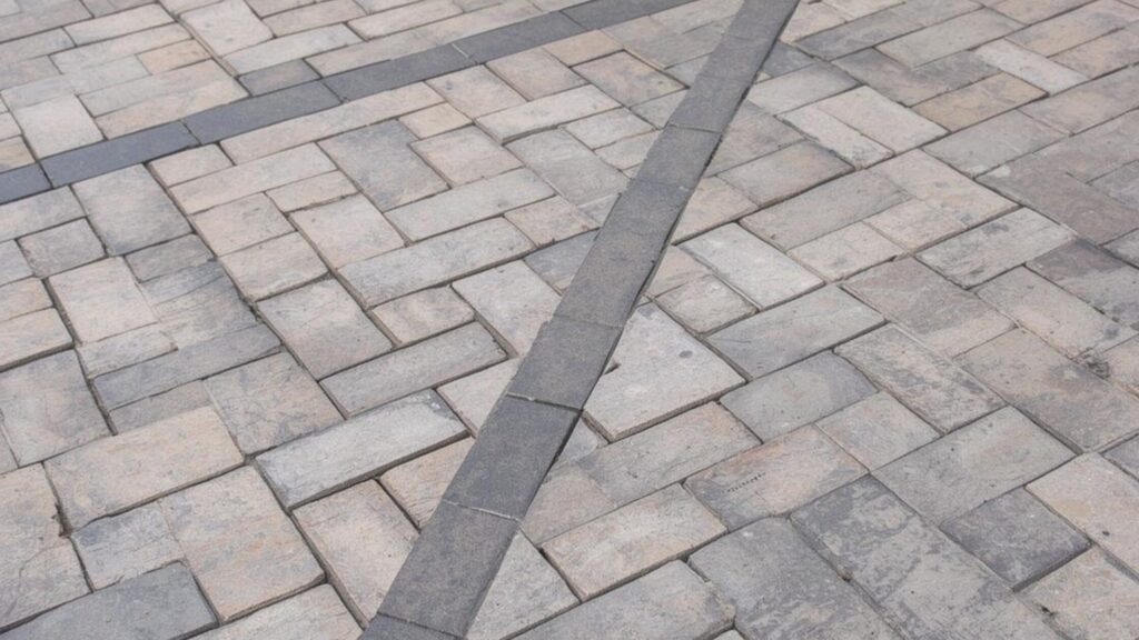 Modular paver pattern creating visual depth Modular paver layout with mixed sizes for patios and outdoor areas