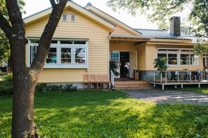 Charming yellow house with wooden windows and green grassy garden budget-friendly siding in east northpoty, NY